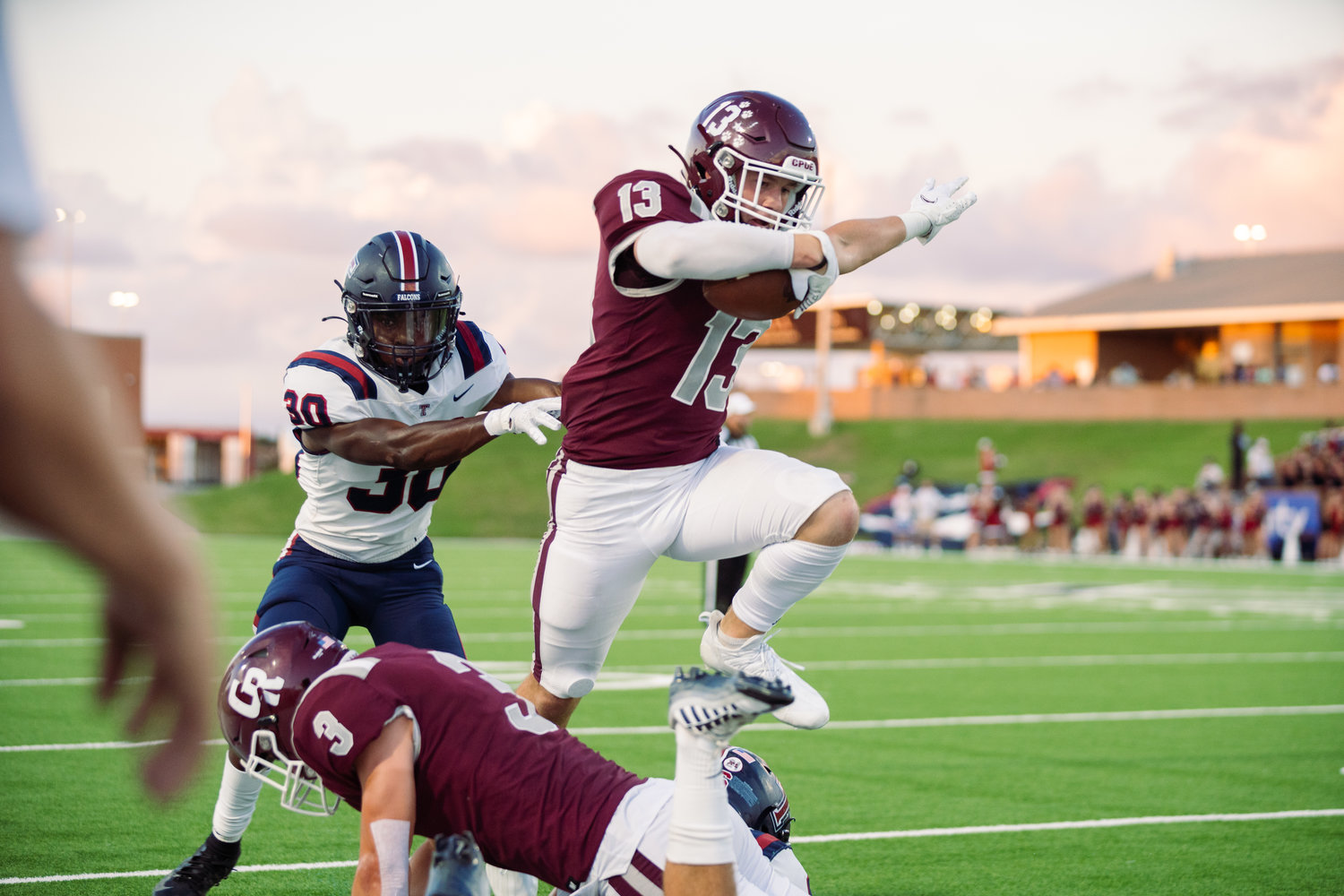 Cinco Ranch’s Fischer Reed hurdles over a teammate and fights for extra yardage during Friday’s game between Cinco Ranch and Tompkins at Rhodes Stadium.